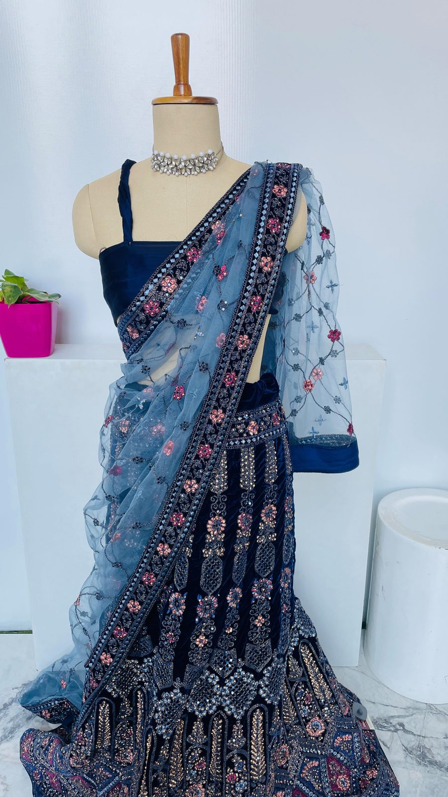 Folded silver-zari Banarasi saree with woven pallu detail on a white surface