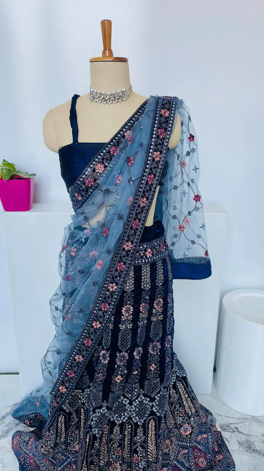 Folded silver-zari Banarasi saree with woven pallu detail on a white surface