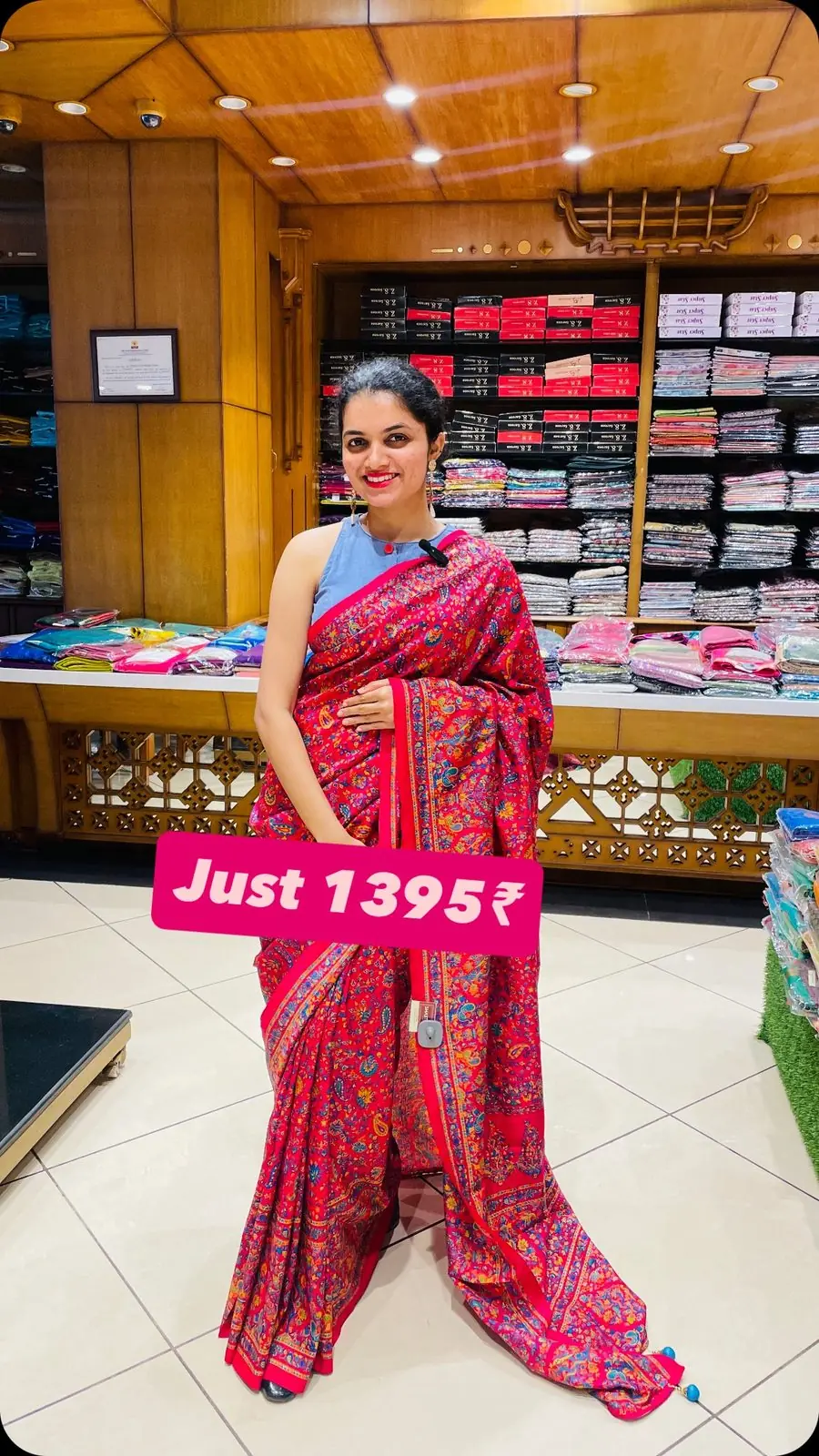 Model folding a mustard cotton-silk saree on a white counter inside the Shasthas store