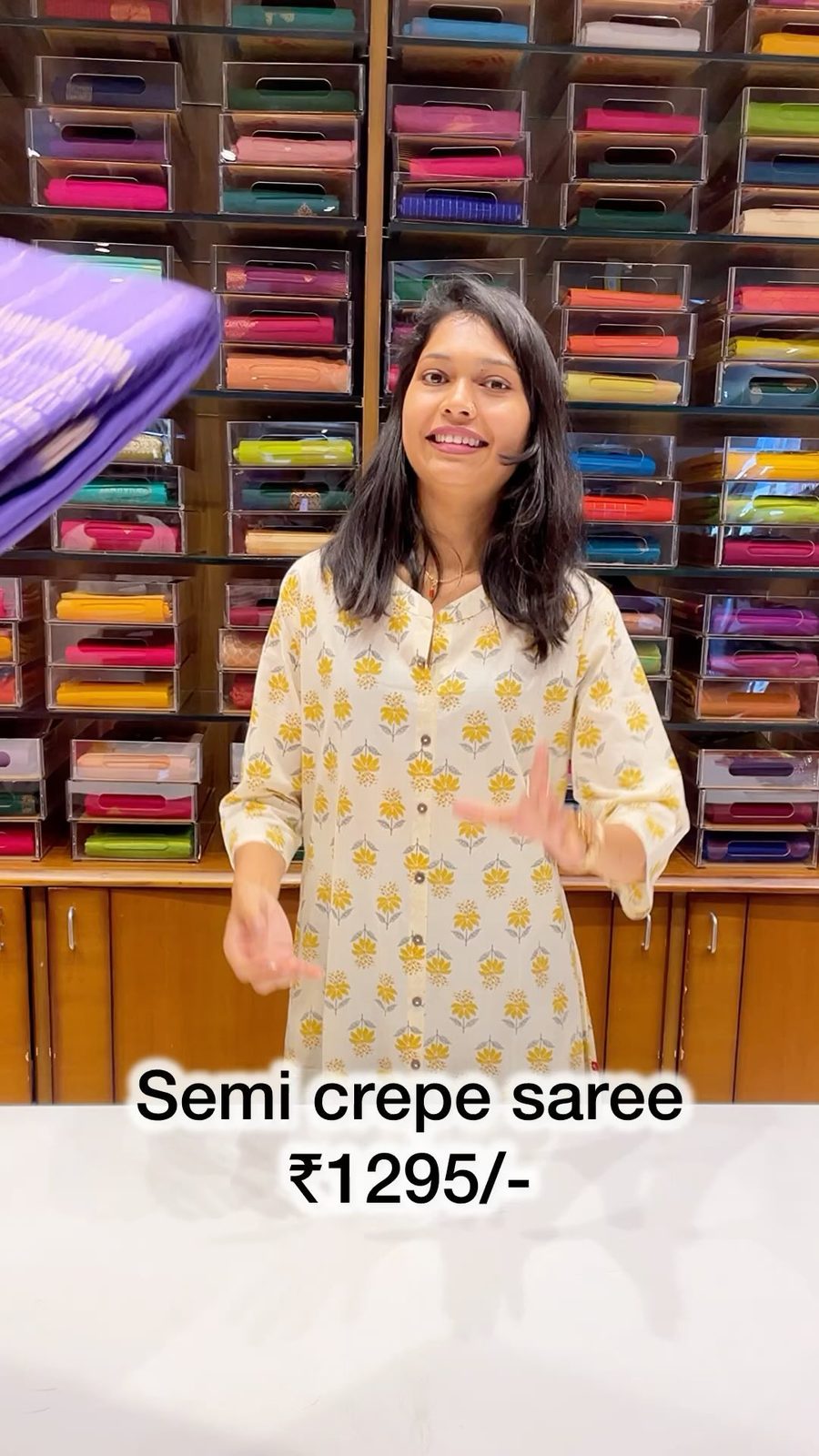 Model in an indigo daily-silk saree inside the Shasthas store with saree shelves behind her