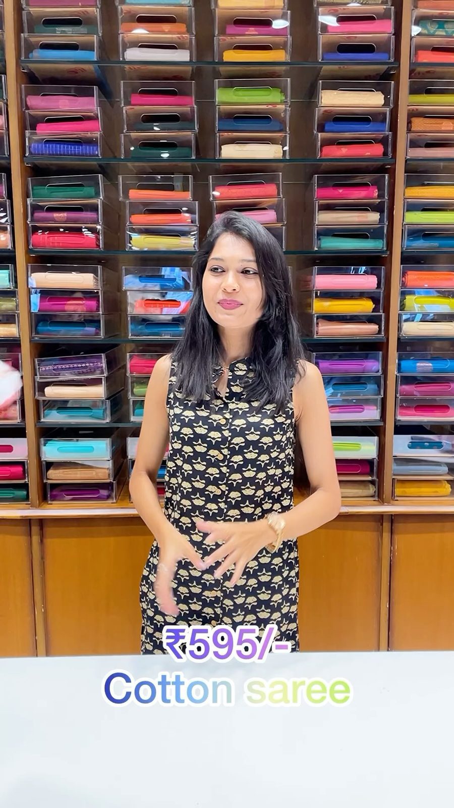 Model wearing a cream semi-crepe saree inside the Shasthas store with saree shelves behind her
