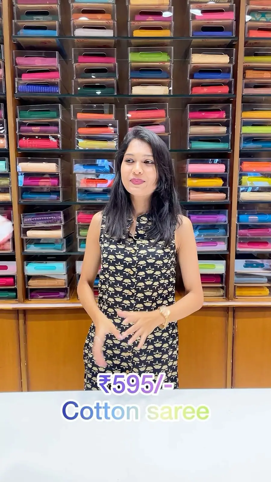 Model wearing a cream semi-crepe saree inside the Shasthas store with saree shelves behind her